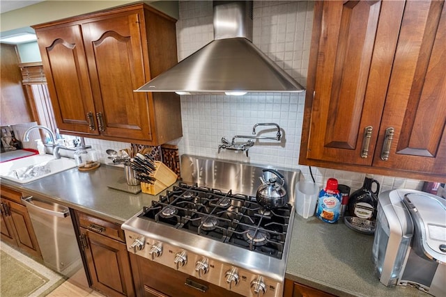 401 Taylor Rd, Independence, KS 67301 - kitchen featuring wall chimney range hood, decorative backsplash, a sink, stainless steel appliances, and brown cabinets
