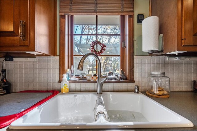 401 Taylor Rd, Independence, KS 67301 - kitchen view of a sink, brown cabinetry, and tasteful backsplash