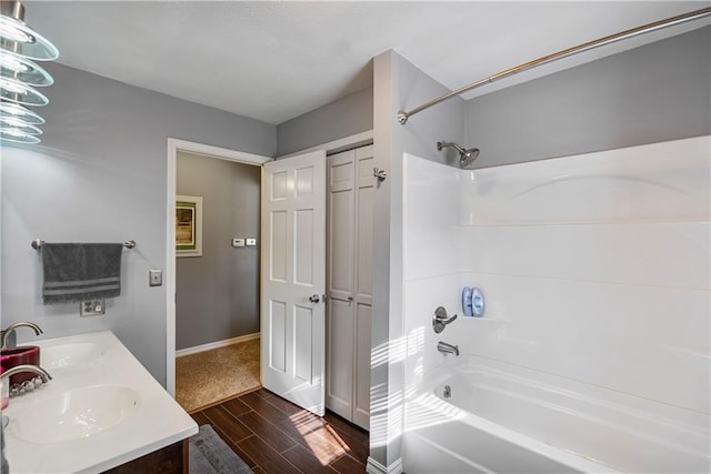 401 Taylor Rd, Independence, KS 67301 - bathroom featuring shower / washtub combination, wood finished floors, baseboards, and double vanity