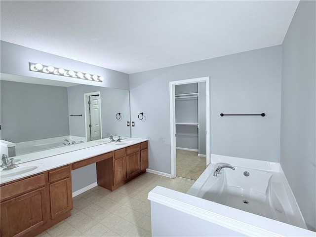 bathroom with double vanity, tile patterned floors, a sink, and a garden tub
