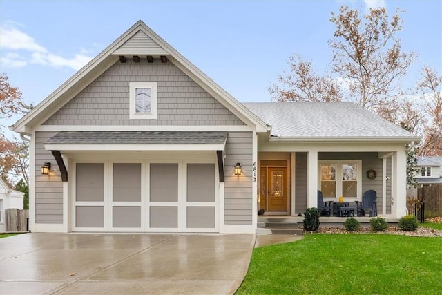 view of front of property with a front lawn, a porch, and a garage