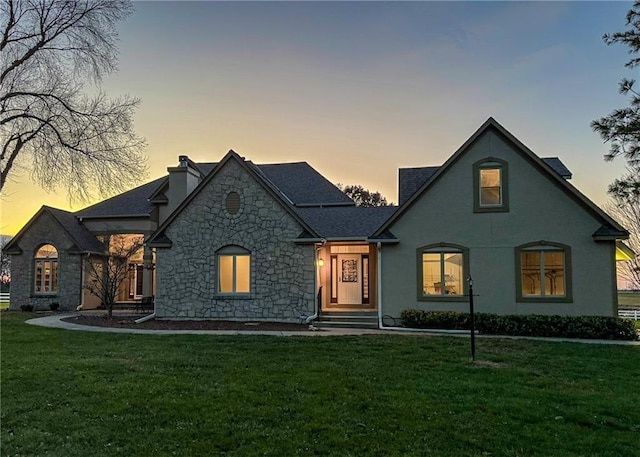 french country home featuring a lawn