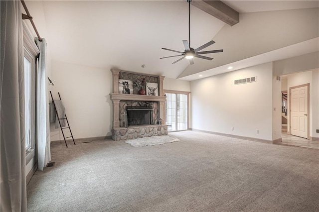 unfurnished living room featuring beamed ceiling, light colored carpet, a fireplace, and ceiling fan