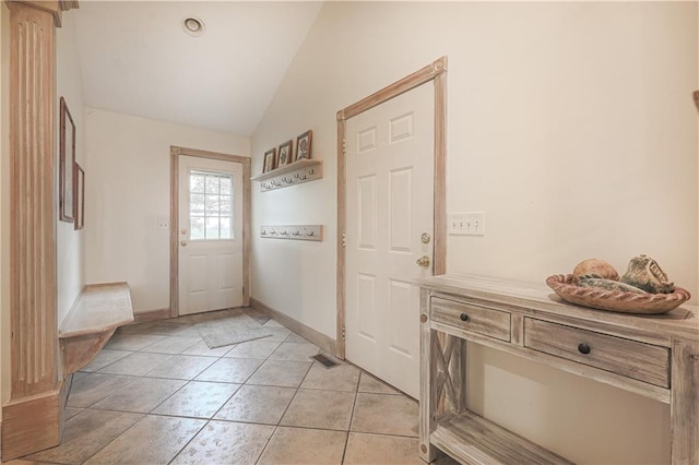 interior space with light tile patterned floors and lofted ceiling