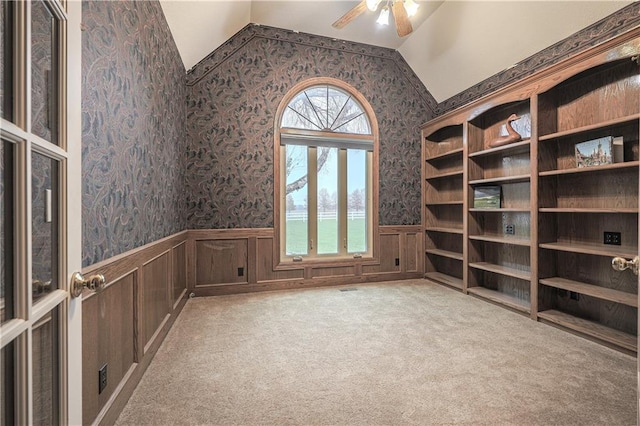 carpeted empty room with a water view and ceiling fan