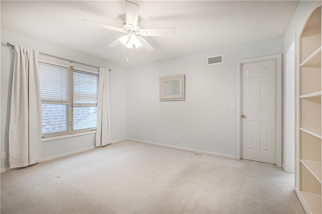 unfurnished room with ceiling fan and light carpet