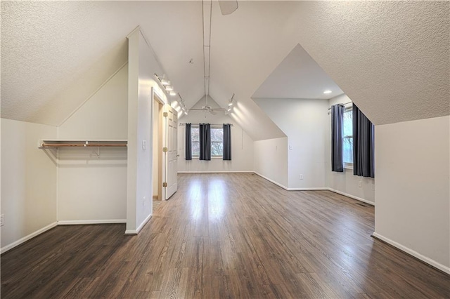 bonus room with dark hardwood / wood-style flooring, a textured ceiling, and vaulted ceiling