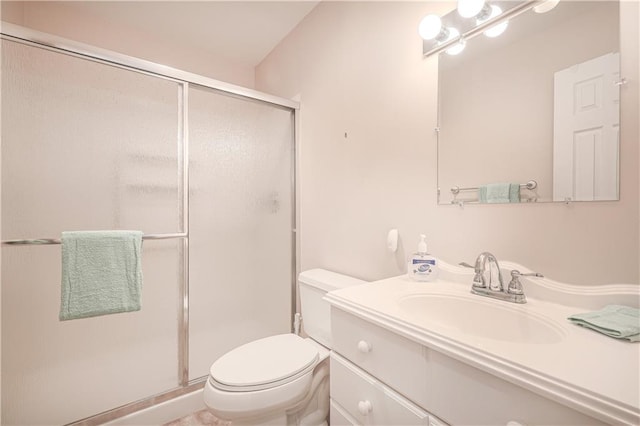 bathroom with a shower with door, vanity, and toilet