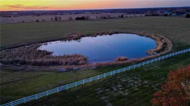 aerial view at dusk with a rural view and a water view