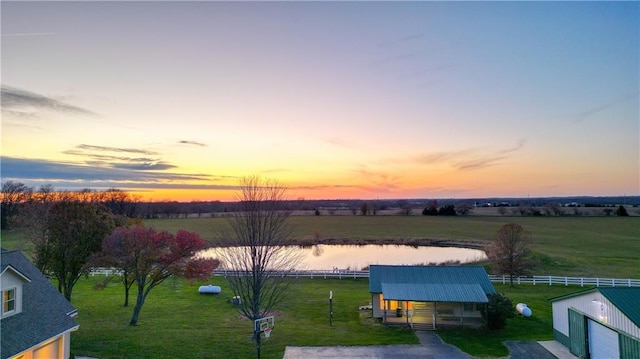 aerial view at dusk with a rural view and a water view