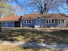 single story home with a garage and a front lawn