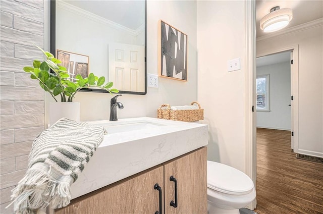 bathroom with vanity, hardwood / wood-style flooring, toilet, and ornamental molding