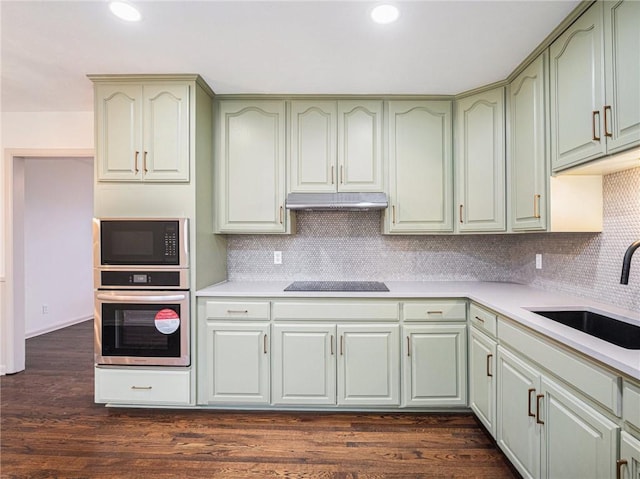 kitchen featuring black appliances, dark hardwood / wood-style floors, green cabinets, and sink