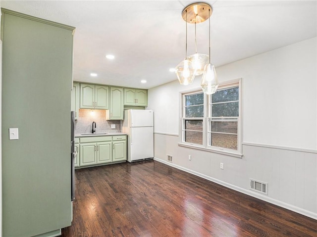 kitchen featuring sink, dark hardwood / wood-style flooring, white refrigerator, decorative backsplash, and green cabinetry