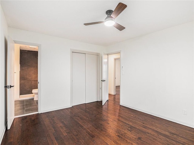 unfurnished bedroom featuring ceiling fan, dark hardwood / wood-style floors, ensuite bathroom, and a closet