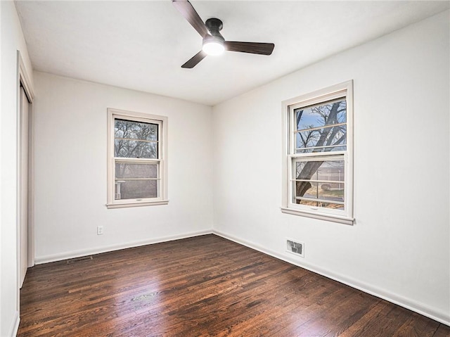 empty room with ceiling fan and dark hardwood / wood-style floors