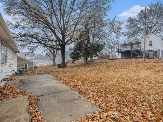 view of yard with central air condition unit and a patio area