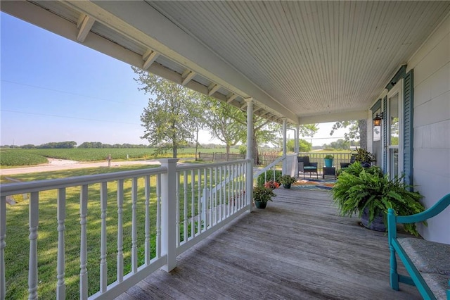 deck with a lawn, a rural view, and a porch