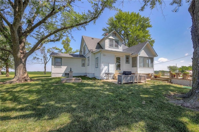 rear view of property with a lawn and a wooden deck