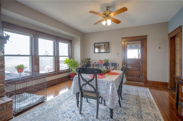 dining space featuring ceiling fan, hardwood / wood-style floors, and a textured ceiling