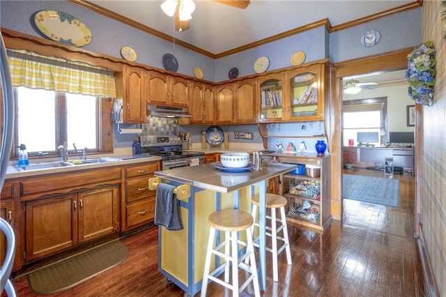 kitchen with a kitchen breakfast bar, stainless steel range with electric stovetop, dark wood-type flooring, crown molding, and a kitchen island