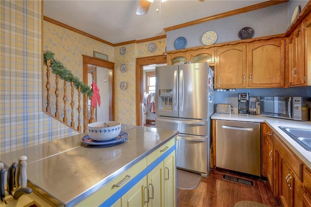 kitchen with dark hardwood / wood-style flooring, ornamental molding, stainless steel appliances, ceiling fan, and sink