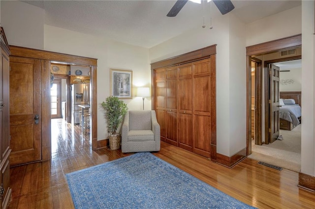 sitting room featuring ceiling fan and wood-type flooring