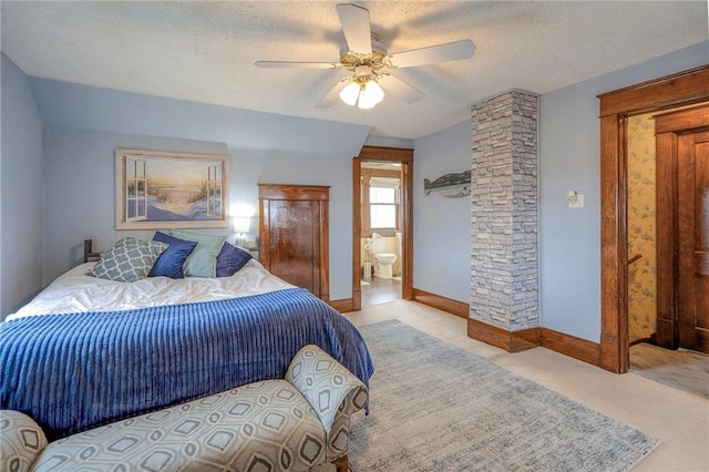 bedroom with connected bathroom, ceiling fan, ornate columns, a textured ceiling, and light carpet