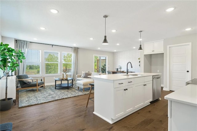 kitchen featuring white cabinetry, sink, stainless steel dishwasher, an island with sink, and decorative light fixtures