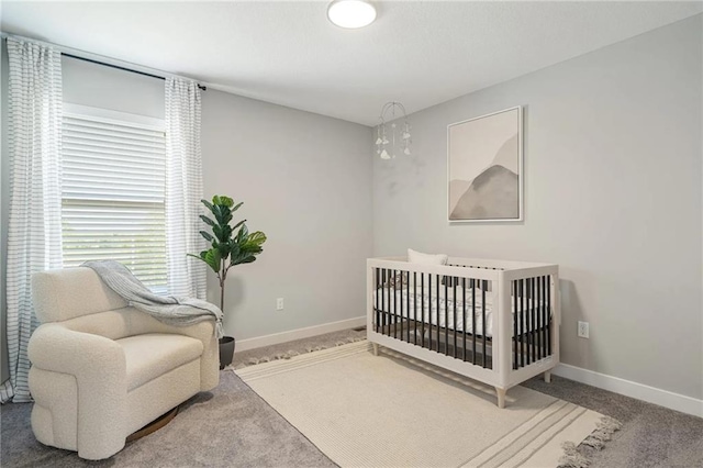 bedroom with carpet flooring, a crib, and a notable chandelier