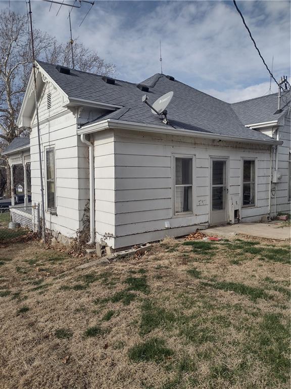 533 4th St, Barnard, MO 64423 - rear view of property featuring a lawn, roof with shingles, and a patio area