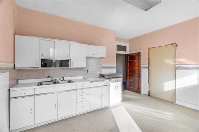 kitchen featuring sink, white cabinetry, and tasteful backsplash