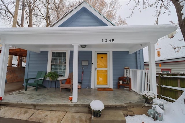 snow covered property entrance featuring a porch