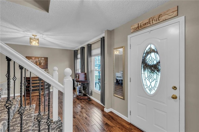 foyer with dark wood-type flooring and a textured ceiling