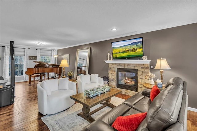 living room featuring hardwood / wood-style floors, crown molding, and a fireplace