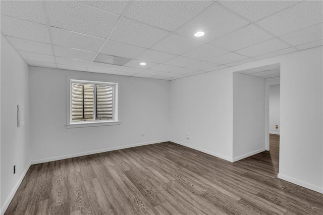 spare room featuring a drop ceiling and hardwood / wood-style flooring