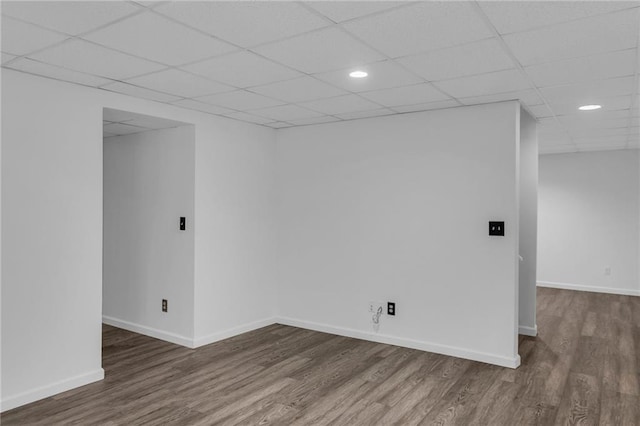 unfurnished room featuring wood-type flooring and a drop ceiling