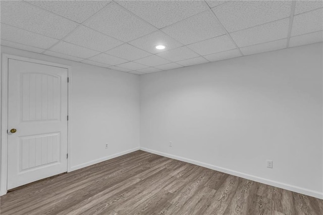 empty room with hardwood / wood-style flooring and a drop ceiling