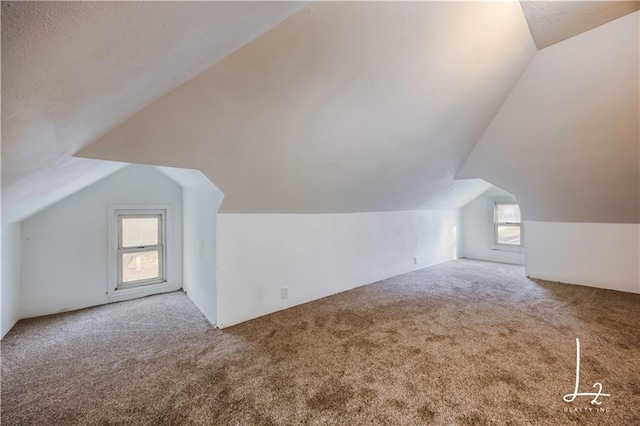 bonus room with carpet flooring and lofted ceiling