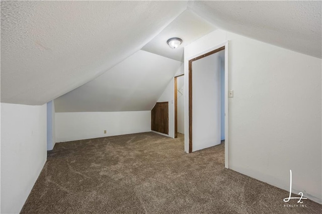 bonus room with a textured ceiling, lofted ceiling, and carpet floors