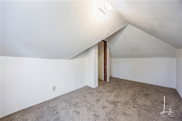 bonus room with a textured ceiling, lofted ceiling, and carpet floors