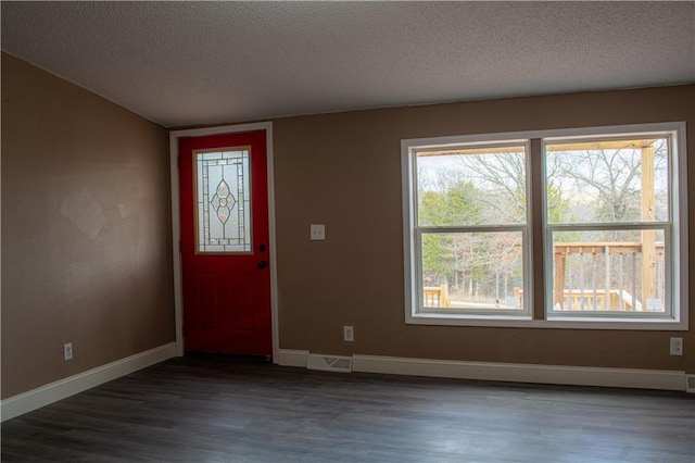 entryway with a textured ceiling and dark hardwood / wood-style floors