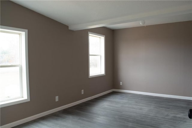 unfurnished room with plenty of natural light and dark wood-type flooring