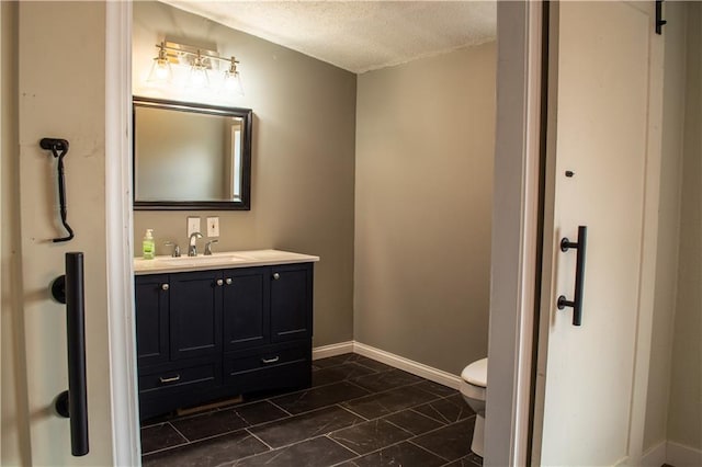 bathroom featuring vanity, toilet, and a textured ceiling