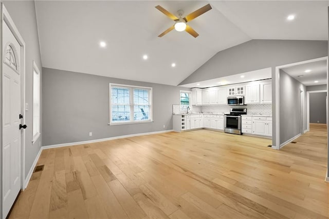 unfurnished living room featuring ceiling fan, light hardwood / wood-style floors, lofted ceiling, and sink