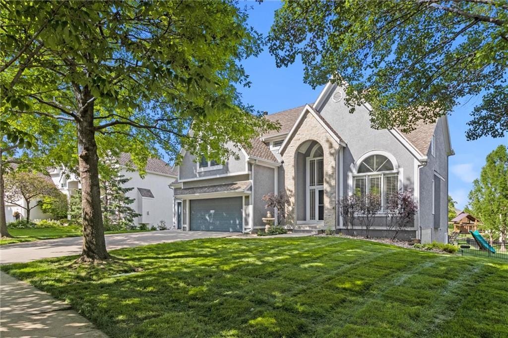 view of front of property featuring a garage and a front lawn