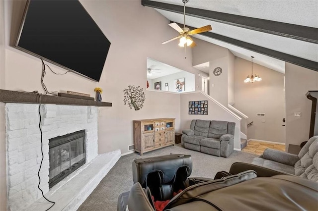 living room featuring ceiling fan with notable chandelier, carpet flooring, a stone fireplace, and lofted ceiling with beams