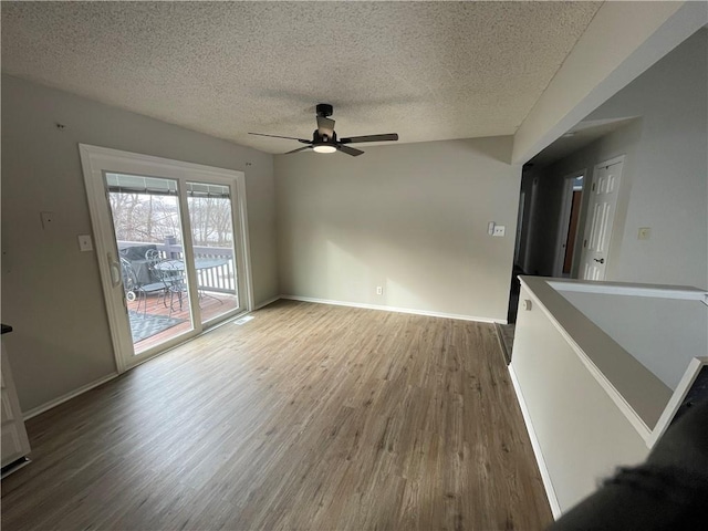 unfurnished living room with hardwood / wood-style flooring, ceiling fan, and a textured ceiling