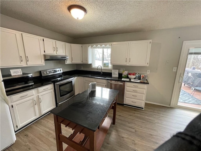 kitchen featuring appliances with stainless steel finishes, sink, white cabinets, and a textured ceiling