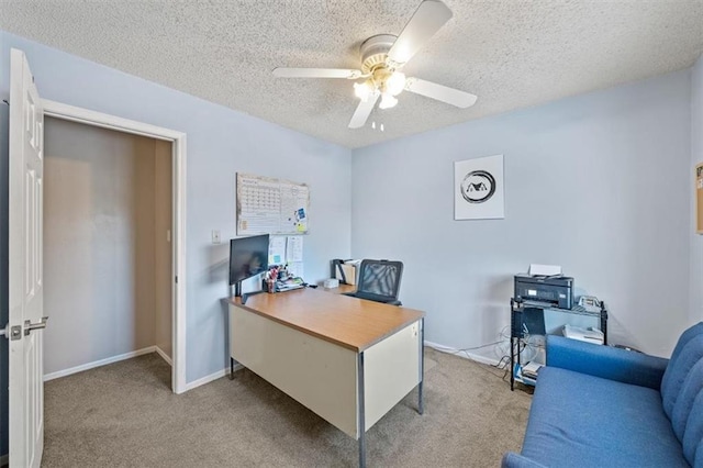 carpeted home office featuring ceiling fan and a textured ceiling